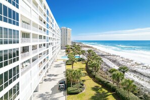 A modern hotel with a pool, a beach view, and a parking area. - Luxurious Oceania 805 w/Beach Service (Destin)