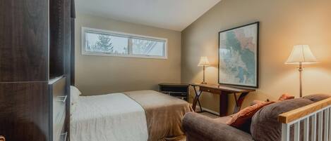 A bedroom with two beds, a desk, a chair, a map on the wall, and skylights.