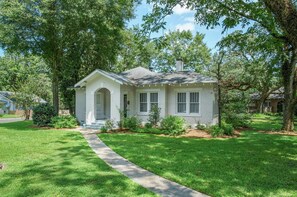 A single-story house with a front entrance, a small porch, and a well-maintained lawn.