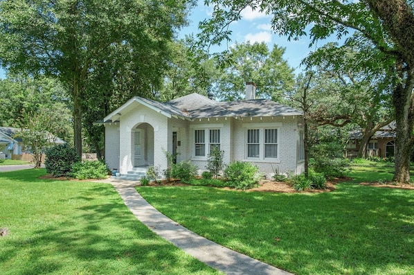 A single-story house with a front entrance, a small porch, and a well-maintained lawn.