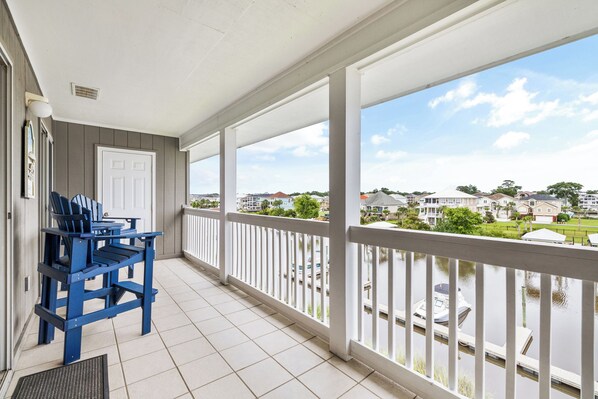 A covered balcony with a view of a residential area and a body of water. - Carolina Yacht Landing 16 (Little River)