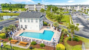 A hotel with a swimming pool, lounge chairs, and a parking lot. - Carolina Yacht Landing 16 (Little River)