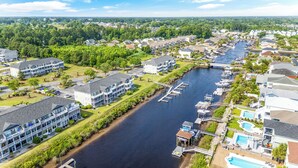 Zona residencial a orillas del río con casas modernas, un puerto deportivo y una piscina.