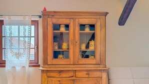 A wooden cabinet with glass doors containing decorative items. - La Perle du Ried n°9 - Alsatian charm between Strasbourg, Colmar and Europapark (Boofzheim)