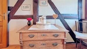 A rustic wooden chest with drawers, a vase with flowers, and a decorative item on top. - La Perle du Ried n°9 - Alsatian charm between Strasbourg, Colmar and Europapark (Boofzheim)