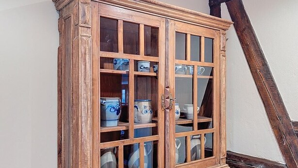 A wooden cabinet with glass doors, containing various ceramic items. - La Perle du Ried n°8 - Alsatian charm & serenity, just a stone's throw from Europa-Park (Boofzheim)