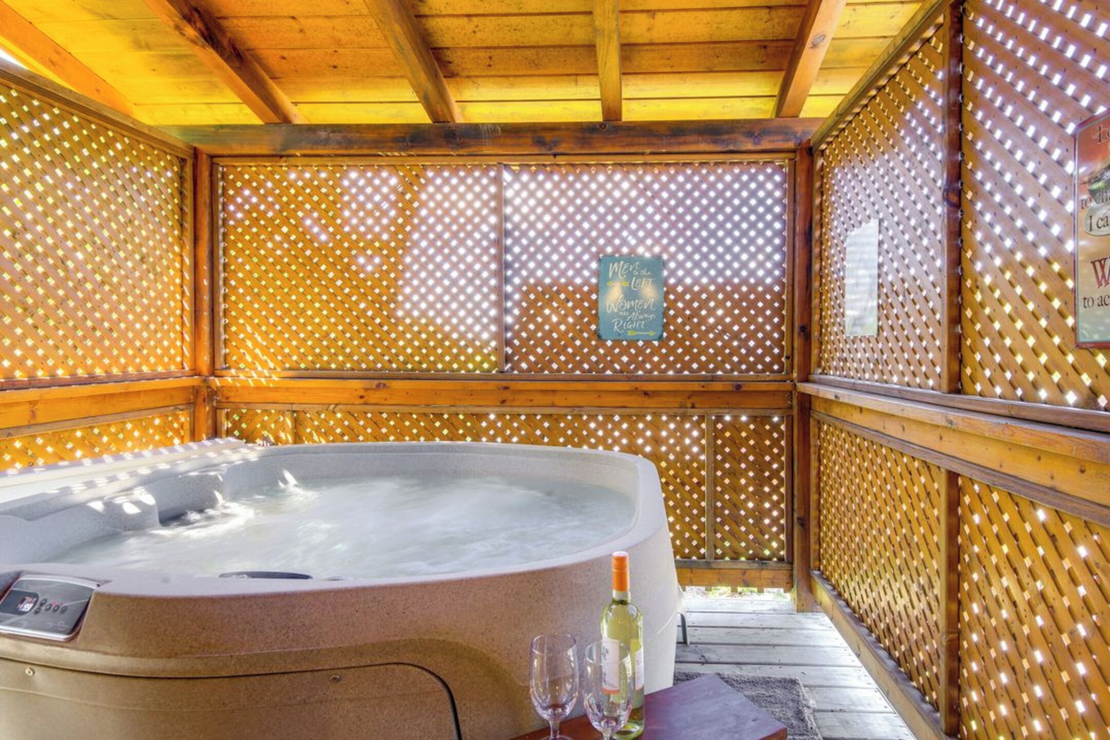 Unwind in your private hot tub sanctuary, where latticed walls create enchanting light patterns and warm wood surrounds you in pure relaxation.