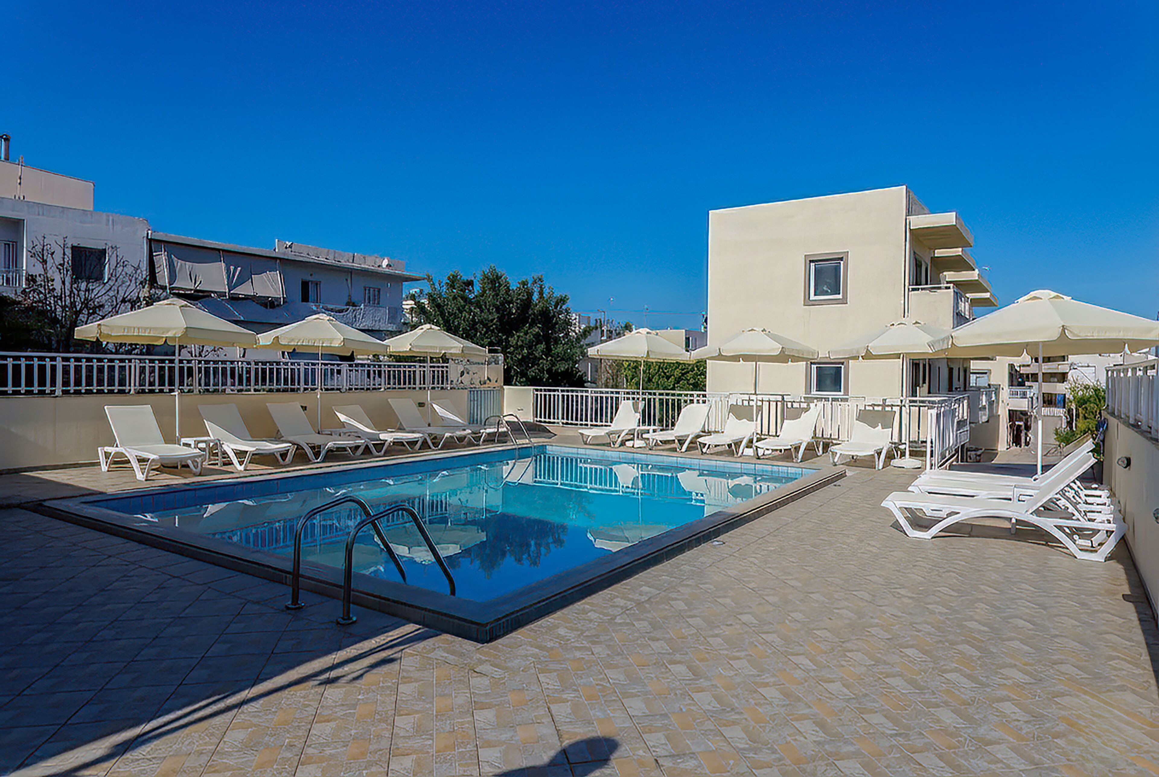Una piscina al aire libre de temporada, sillones reclinables de piscina
