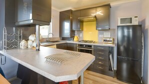 Eine moderne Küche mit Edelstahlgeräten, einem Backofen und einer Mikrowelle.