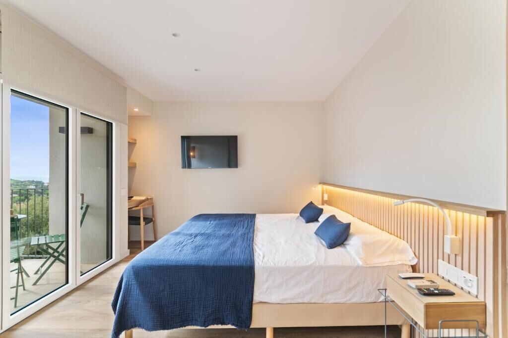 Un dormitorio moderno con una cama grande, un escritorio y un televisor.