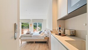 A bedroom with a bed, bedside table, and a view of the outdoors. - L'Hostalet de Cabrils (Cabrils)