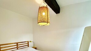 A single bed with a wooden frame and white bedding in a room with wooden flooring and a sloped ceiling. - Le SAINT CLEMENT in the heart of Nantes 5min from Nantes Nord train station (Nantes)