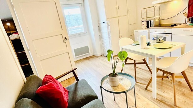 A modern apartment with a loft-style kitchen, a dining area, and a cozy seating area with a sofa and a small side table. - Le SAINT CLEMENT in the heart of Nantes 5min from Nantes Nord train station (Nantes)