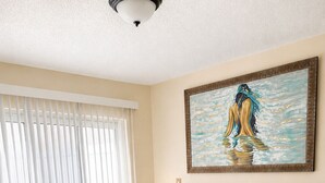 A hotel room with a large bed, a nightstand, a lamp, and a painting on the wall. - E&A SouthWest Miami Rentals Cozy 2BD Apartment with Private Parking (miami)
