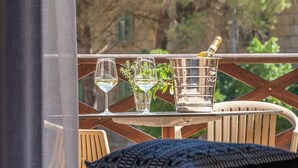 Un tavolo con una bottiglia di champagne, due bicchieri da vino e una piccola pianta.