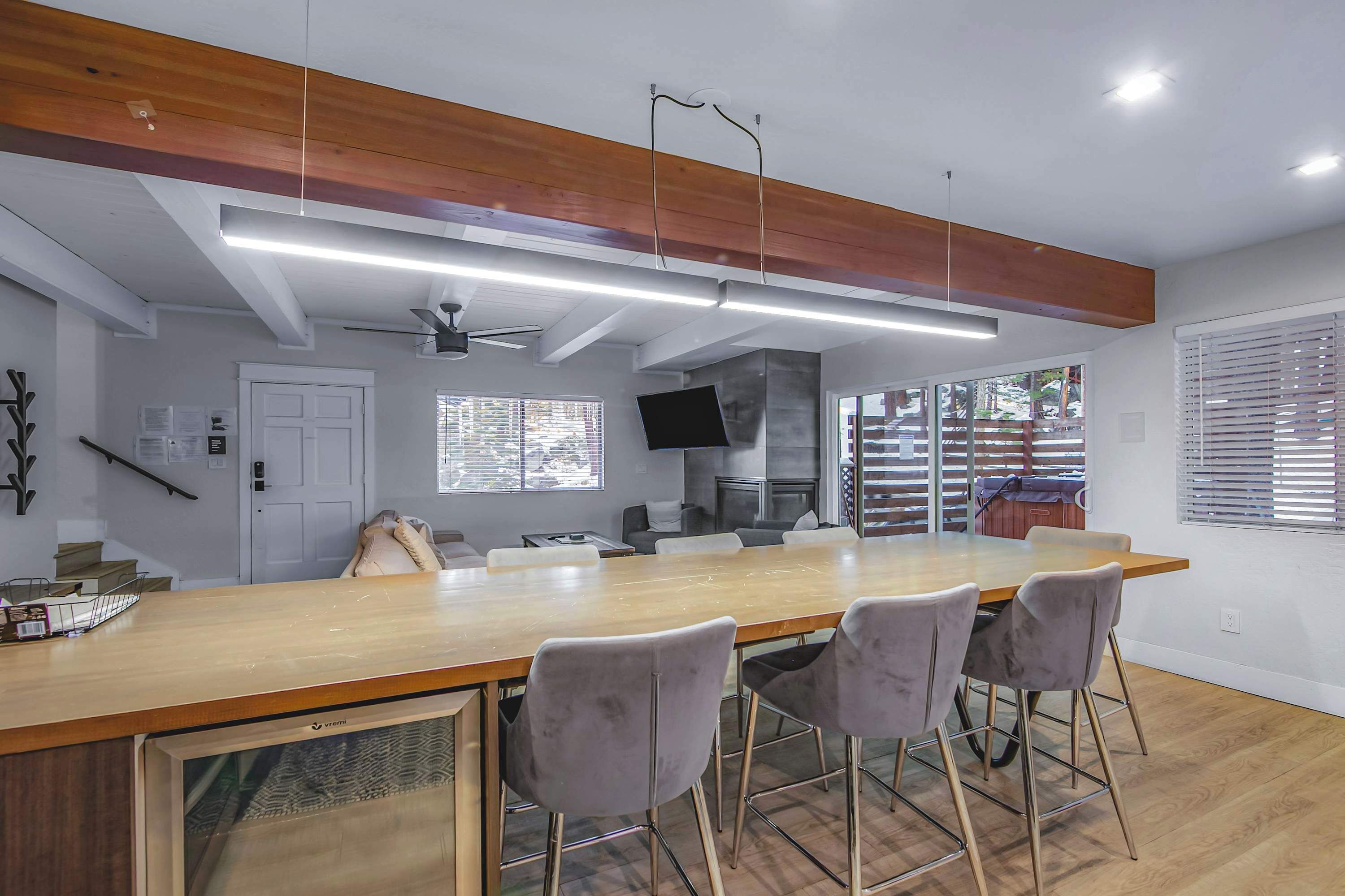 A modern kitchen with a wooden countertop, bar stools, and a large island.