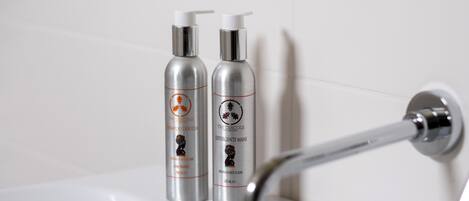 Dos botellas de champú y acondicionador sobre una repisa del baño.