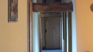 Una escalera de madera con vigas y piso alfombrado que lleva a una puerta.