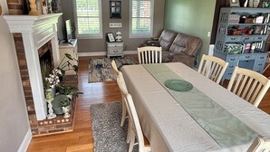 A dining area with a long table, white chairs, and a ceiling fan. - Masters Tournament Rental at a Relaxing Retreat (Jackson)