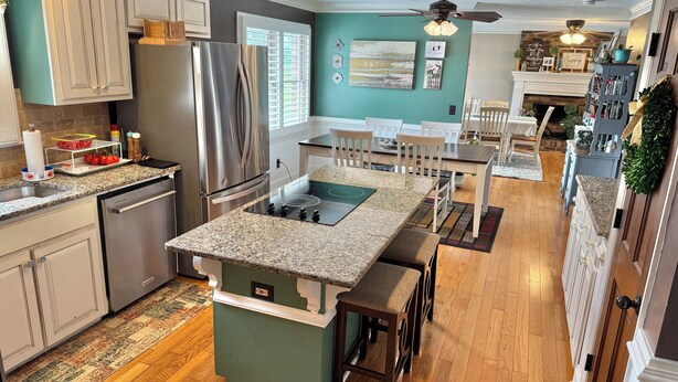 A kitchen with a central island, stainless steel appliances, and a dining area with a table and chairs. - Masters Tournament Rental at a Relaxing Retreat (Jackson)