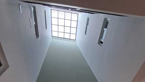 Ein schmaler Flur mit einem Fenster am Ende, einer kleinen Leuchte und dem Wort 