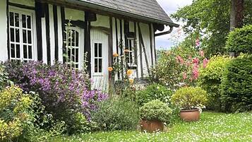 Une maison traditionnelle à colombages avec un jardin.