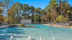A swimming pool with clear water, surrounded by trees and a fenced area with lounge chairs. - ⛱️Bay Views | Tram to Beach | Sandestin Resort | Pool | Vantage Pointe 43☀️ (Miramar Beach)