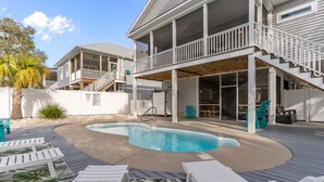 Ein Poolbereich mit Liegestühlen und einer überdachten Terrasse.