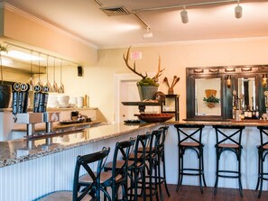 A bar area with a counter, stools, and a decorative antler.