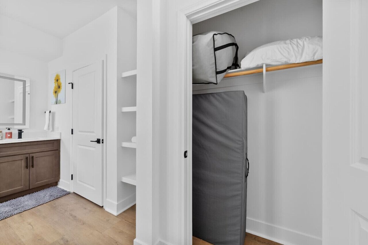 A compact room with a bunk bed, a wardrobe, and a small bathroom area.