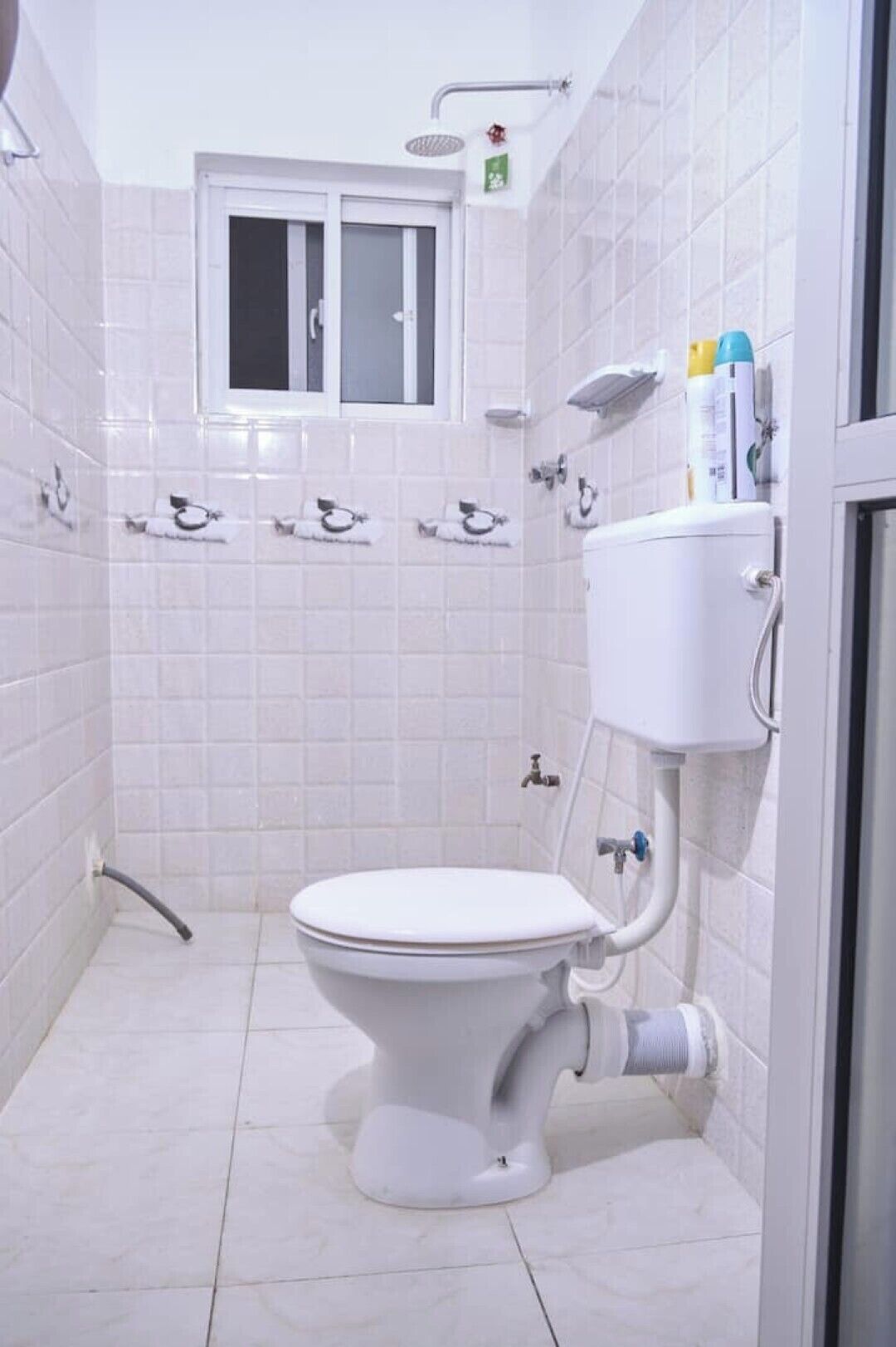 Un baño pequeño y blanco con inodoro, lavabo y ducha.