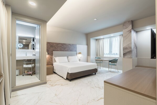 A modern hotel room with a bed, bedside table, and a small desk with a chair. - Baires Guest House (Milan)