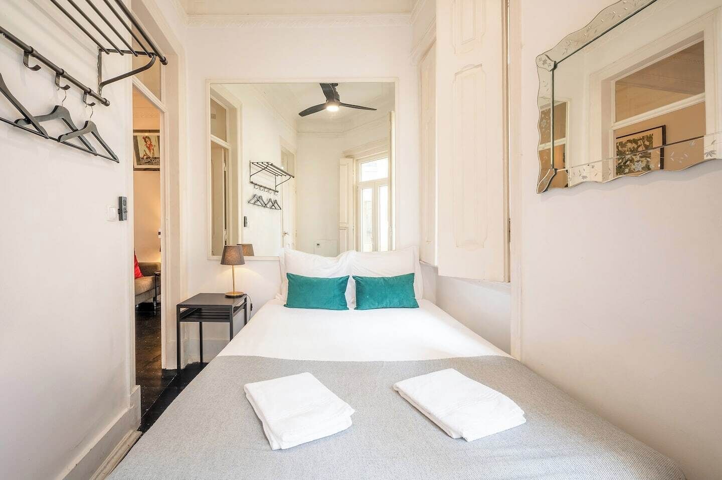 Une chambre d’hôtel avec un lit, une table de chevet, une lampe et un miroir.
