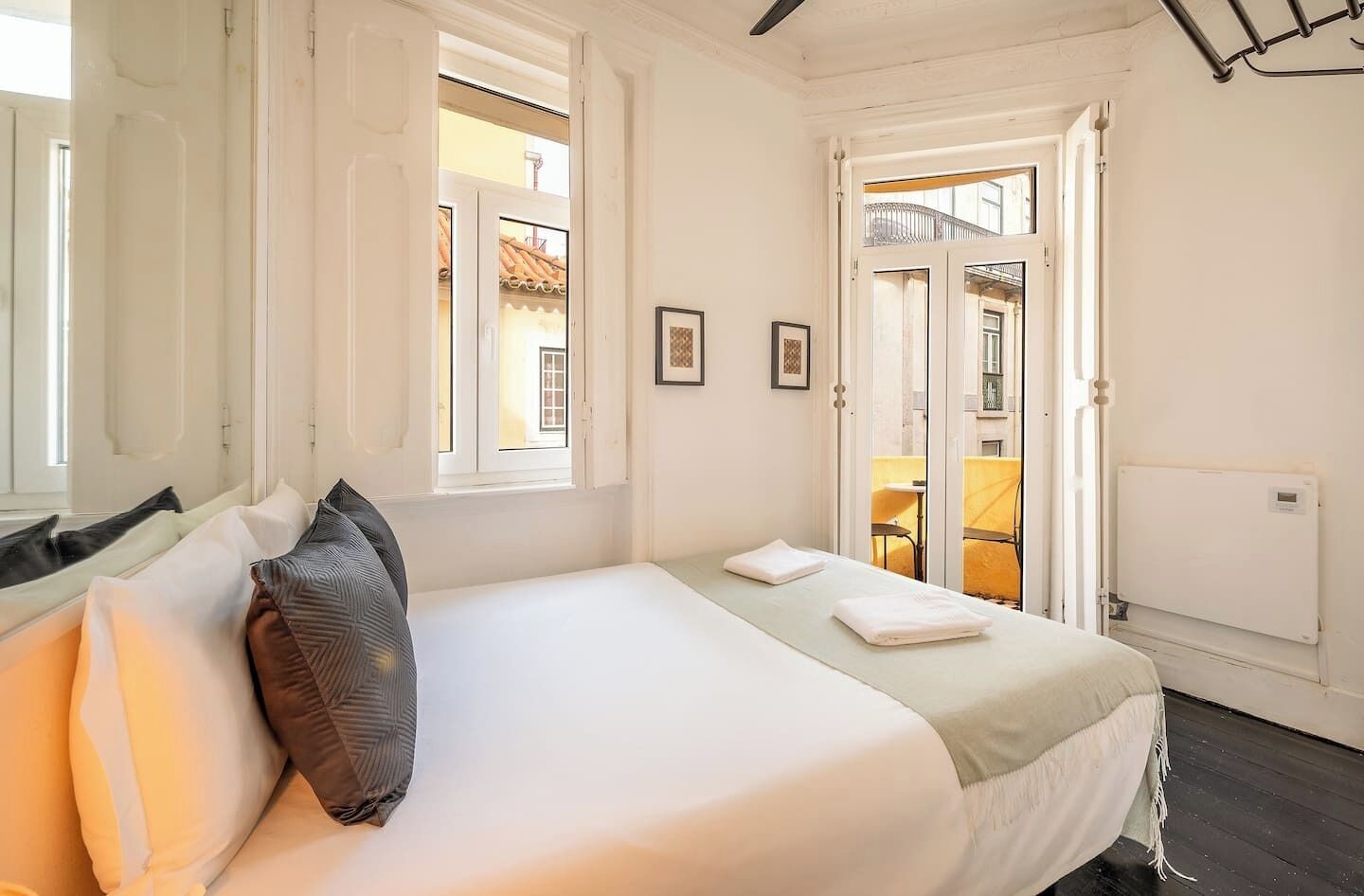 A hotel room with a bed, a window, and a door leading to an outdoor area.