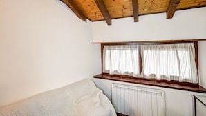 A small, cozy room with a wooden ceiling, a window with curtains, a radiator, and a single bed. - La Maison Pilly - Valtellina (Sondalo)