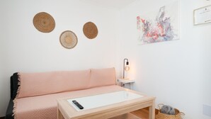 Une pièce confortable avec un canapé, une petite table, une lampe et des éléments décoratifs sur les murs.