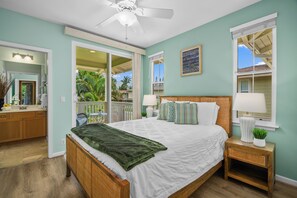 A bedroom with a bed, bedside tables, a ceiling fan, and a view of the outdoors. - Kaimana Villa: Princeville Retreat w/ Pool & AC (Princeville)