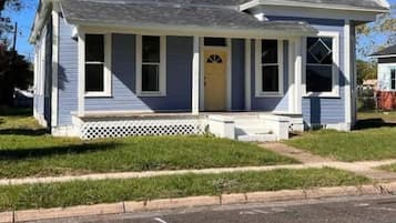 A single-story house with a gabled roof, a front porch, and a small front yard.