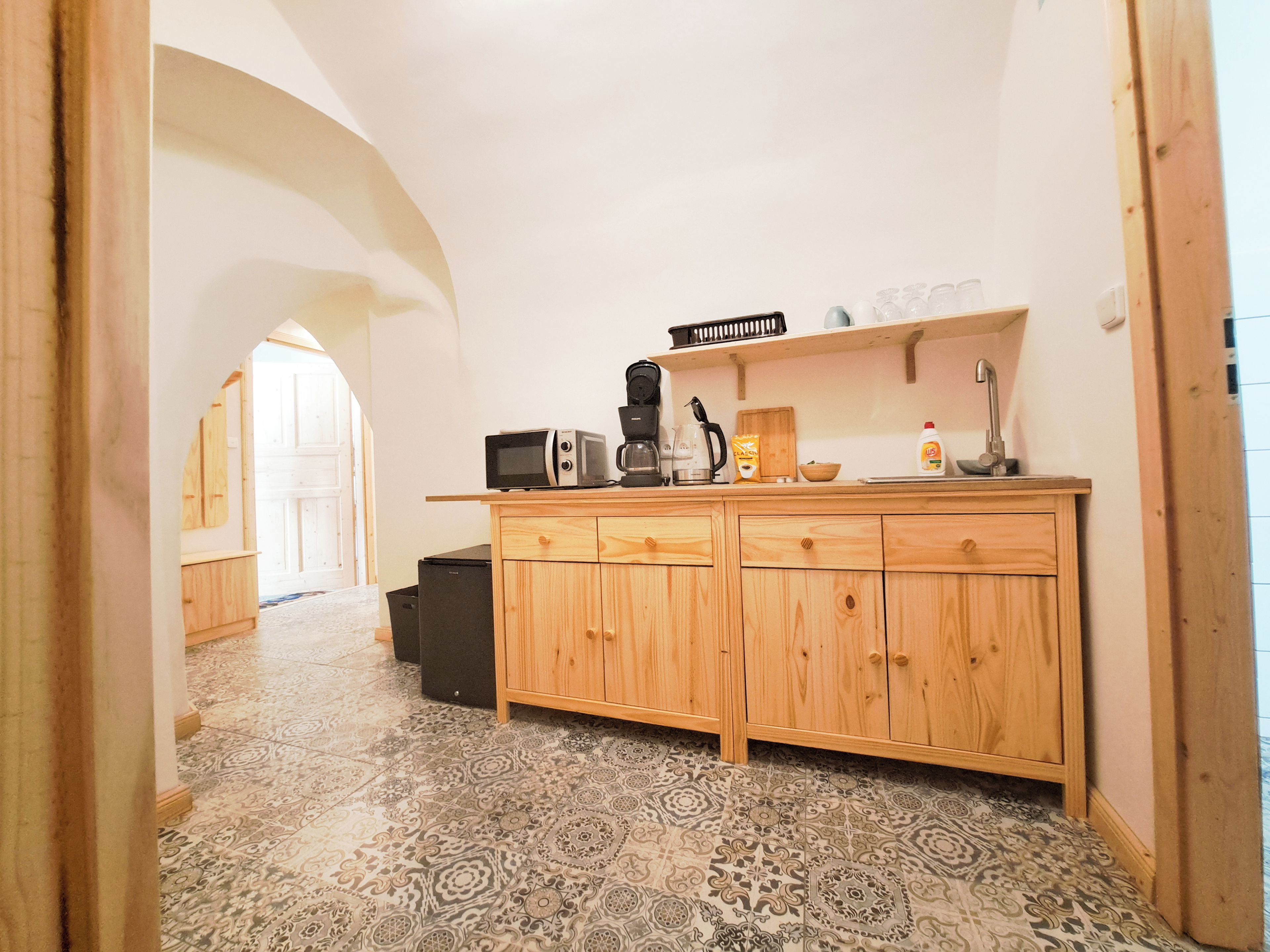 A kitchen with a microwave, coffee maker, and wooden cabinets.