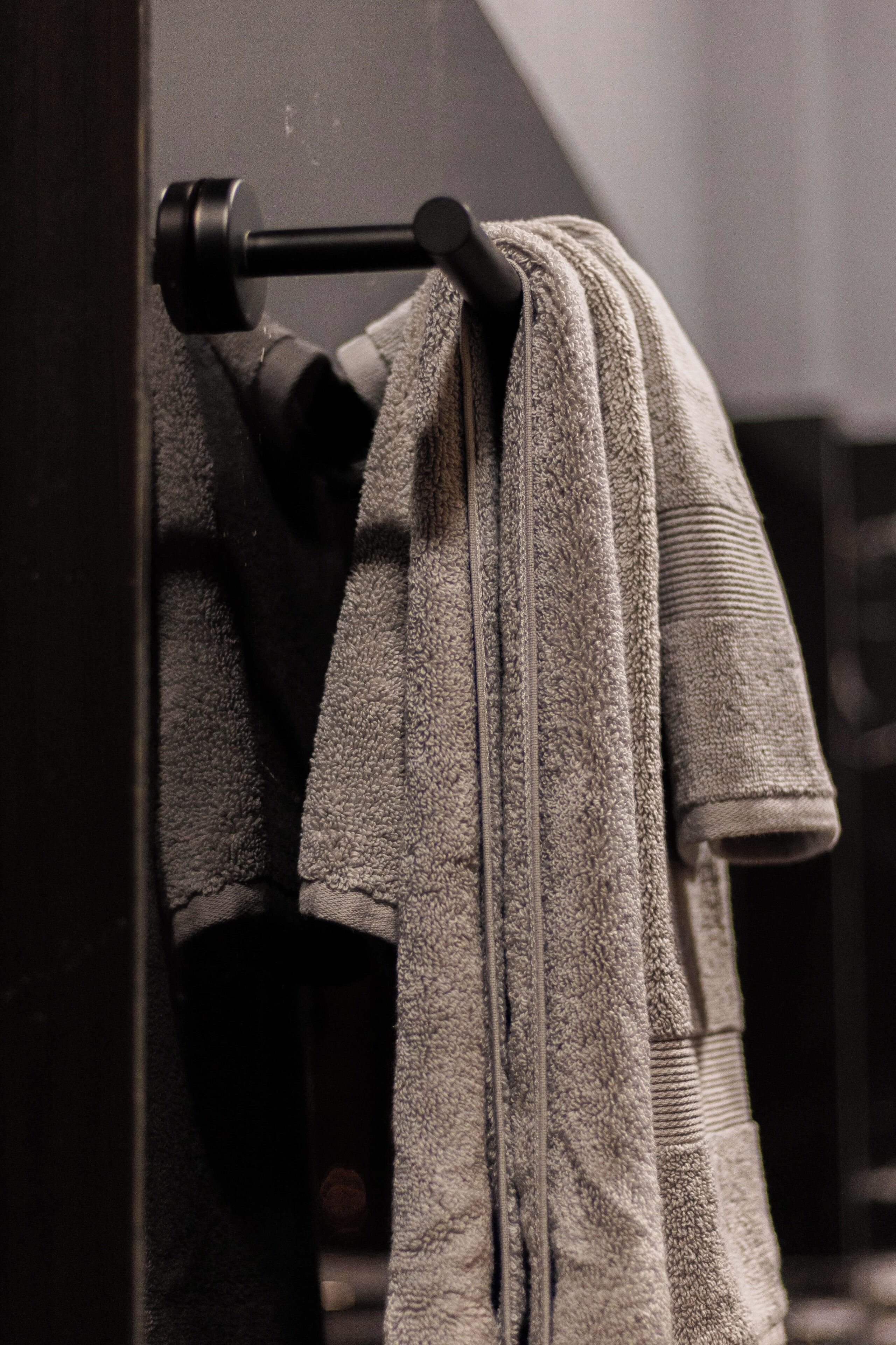 A bathroom with a towel rack holding a folded towel.