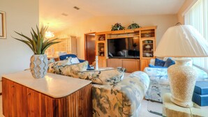 A modern living room with a sofa set, a wooden cabinet, a TV, and a decorative lamp. - Ocala - WEC. (Ocala)