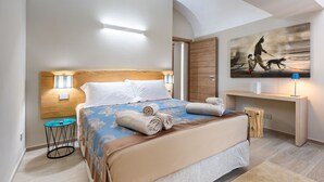 A hotel room with a bed, bedside lamps, a painting, a desk, and a small round table. - Hostdomus - The Court (Alba)