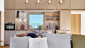 Eine moderne Küche mit Holzausstattung, einem eingebauten Backofen und einem Fenster mit Blick auf eine Stadtlandschaft.