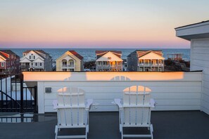 A row of beach houses with a view of the ocean at sunset. - Luxury Condo with Theater, Elevator, GameRm! (Kill Devil Hills)