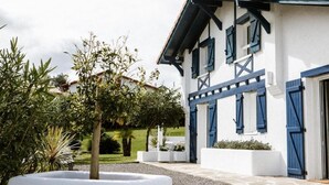 Un edificio bianco con persiane blu e un tetto di tegole.