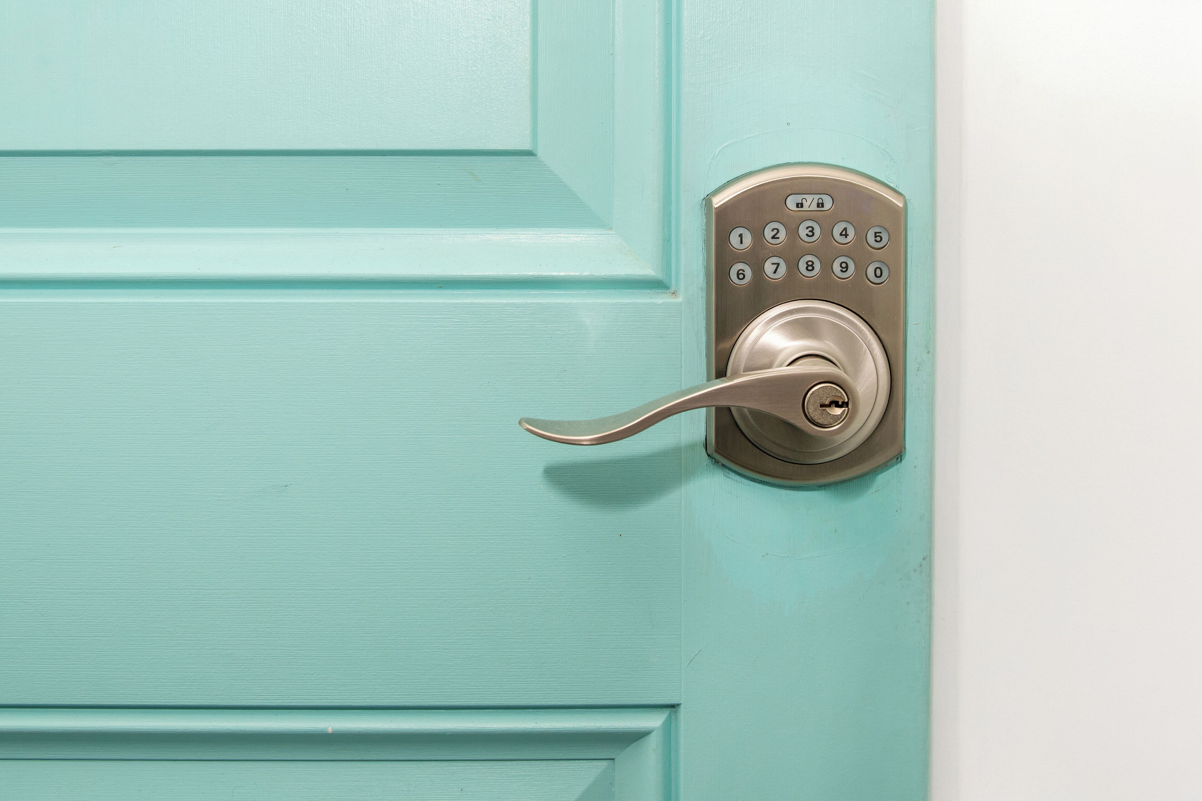 A turquoise door with a numeric keypad lock.