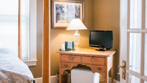 A bedroom with a bed, a desk with a lamp, a TV, and a framed picture on the wall. - Suite 5-Double room-Private Bathroom-Standard (Fish Creek)