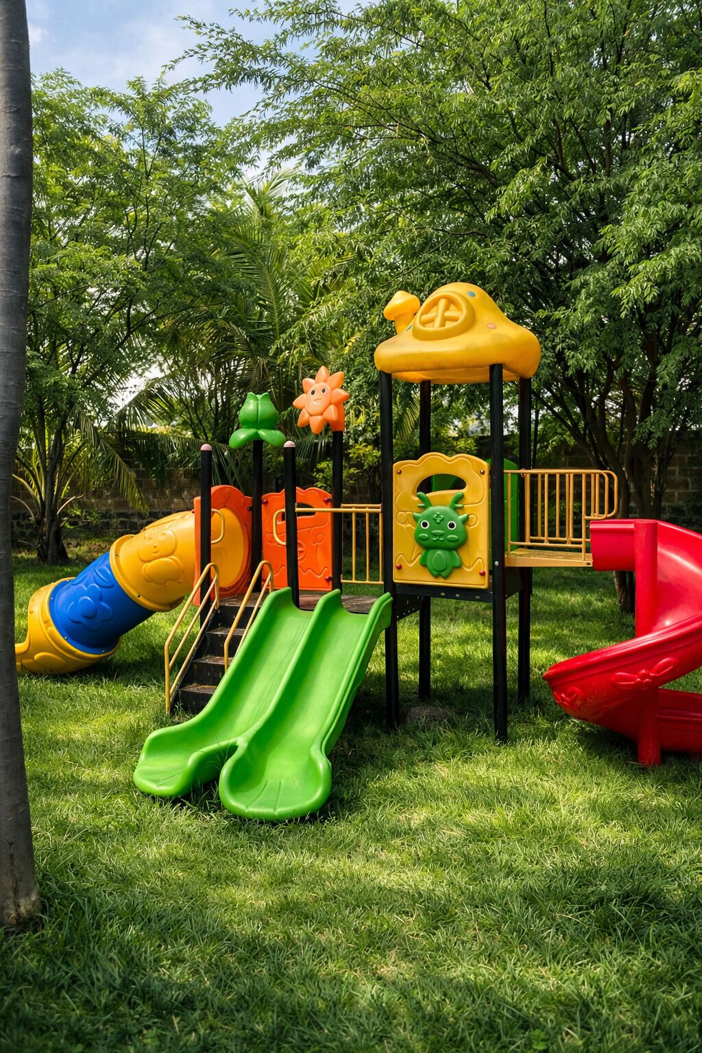 A playground with slides and climbing structures surrounded by trees.