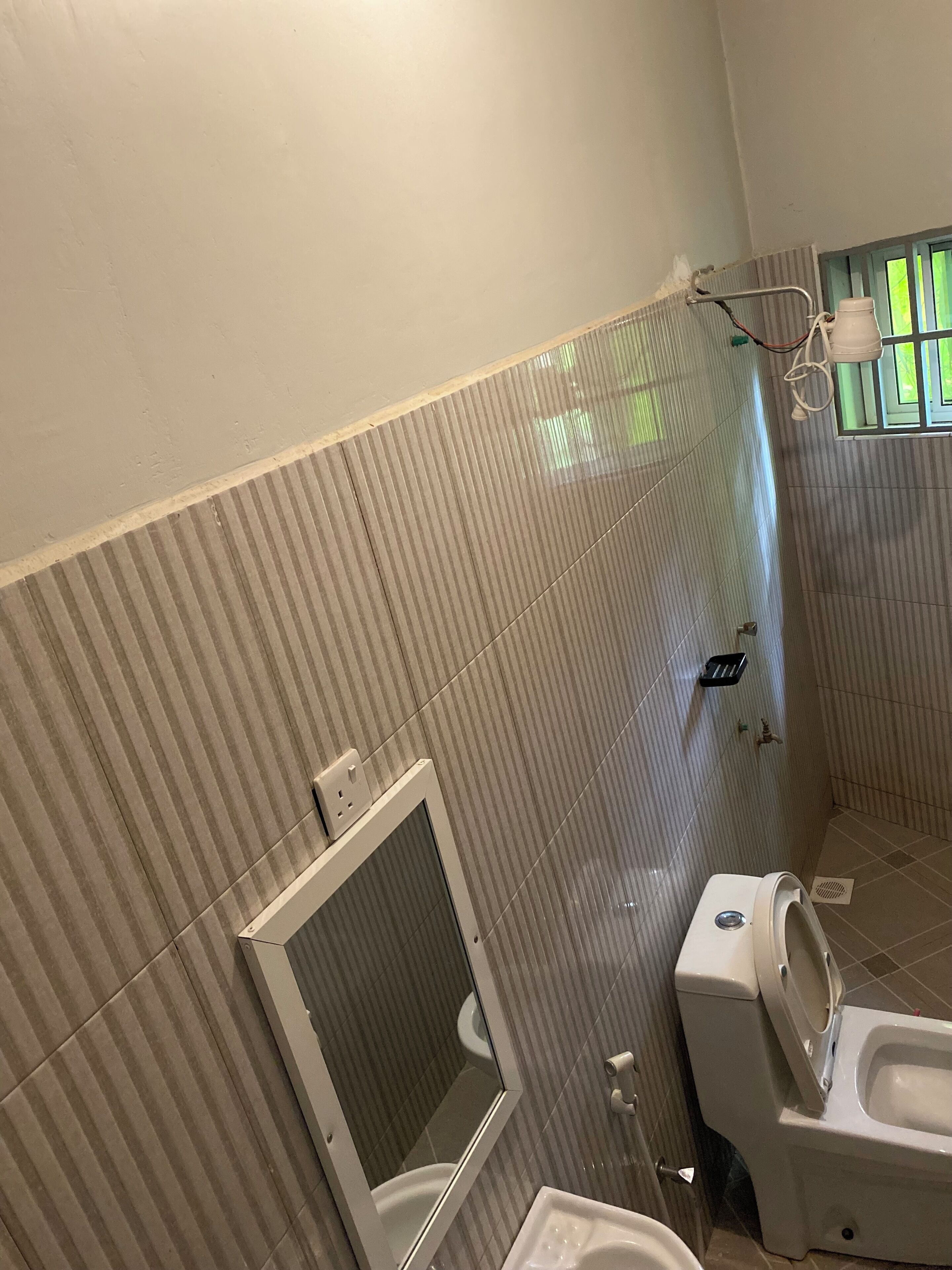 Un baño con inodoro, bidé y una ventana con persianas.