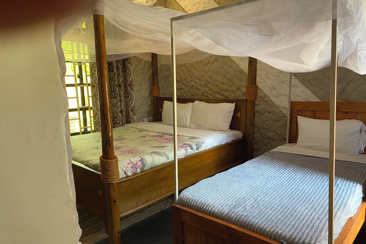 Una habitación con dos camas de madera, cada una con dosel.